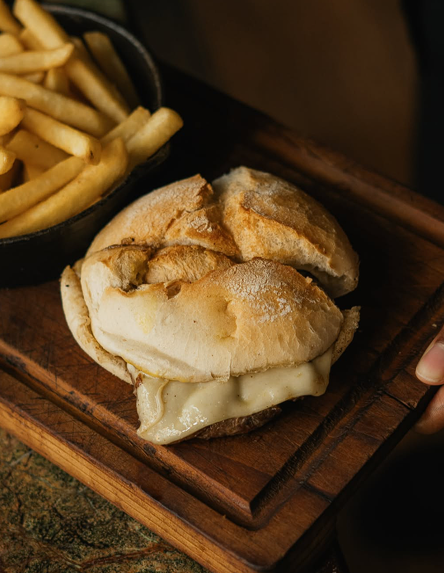 Prego no pão com queijo e batatas fritas servido no ALMA Restaurante Guimarães